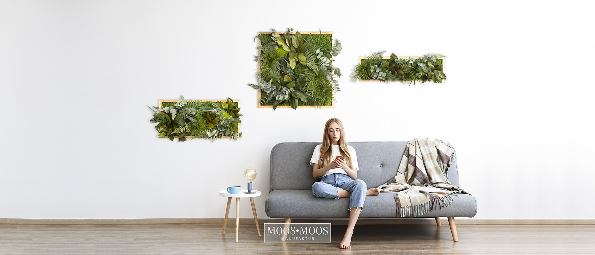 Young beautiful woman wearing white t-shirt on grey textile sofa at home. Attractive slim female in domestic situation, resting on couch in her lofty apartment. Background, copy space, close up.