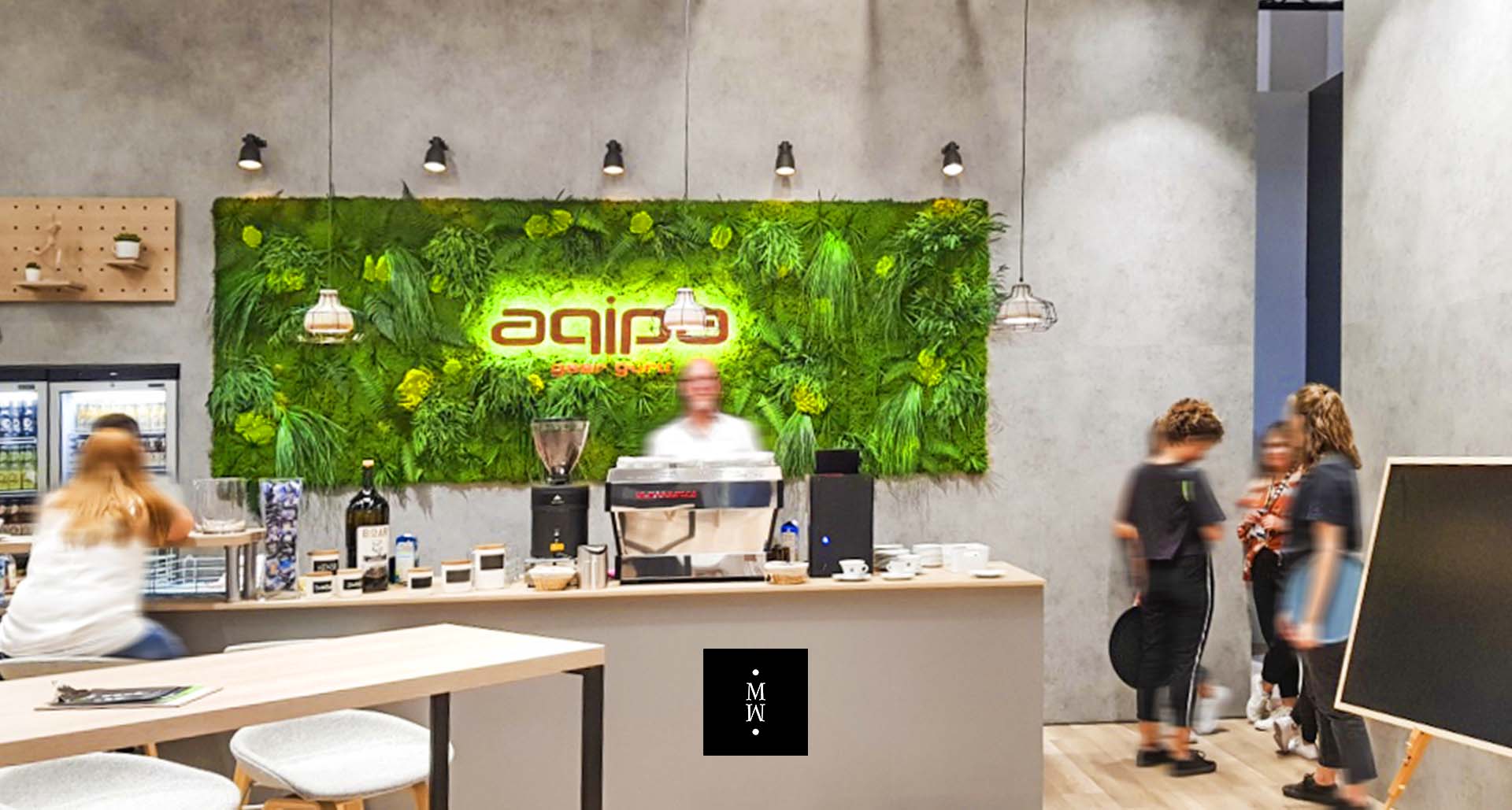 Dschungelmooswand hinter einer Bar mit Logo