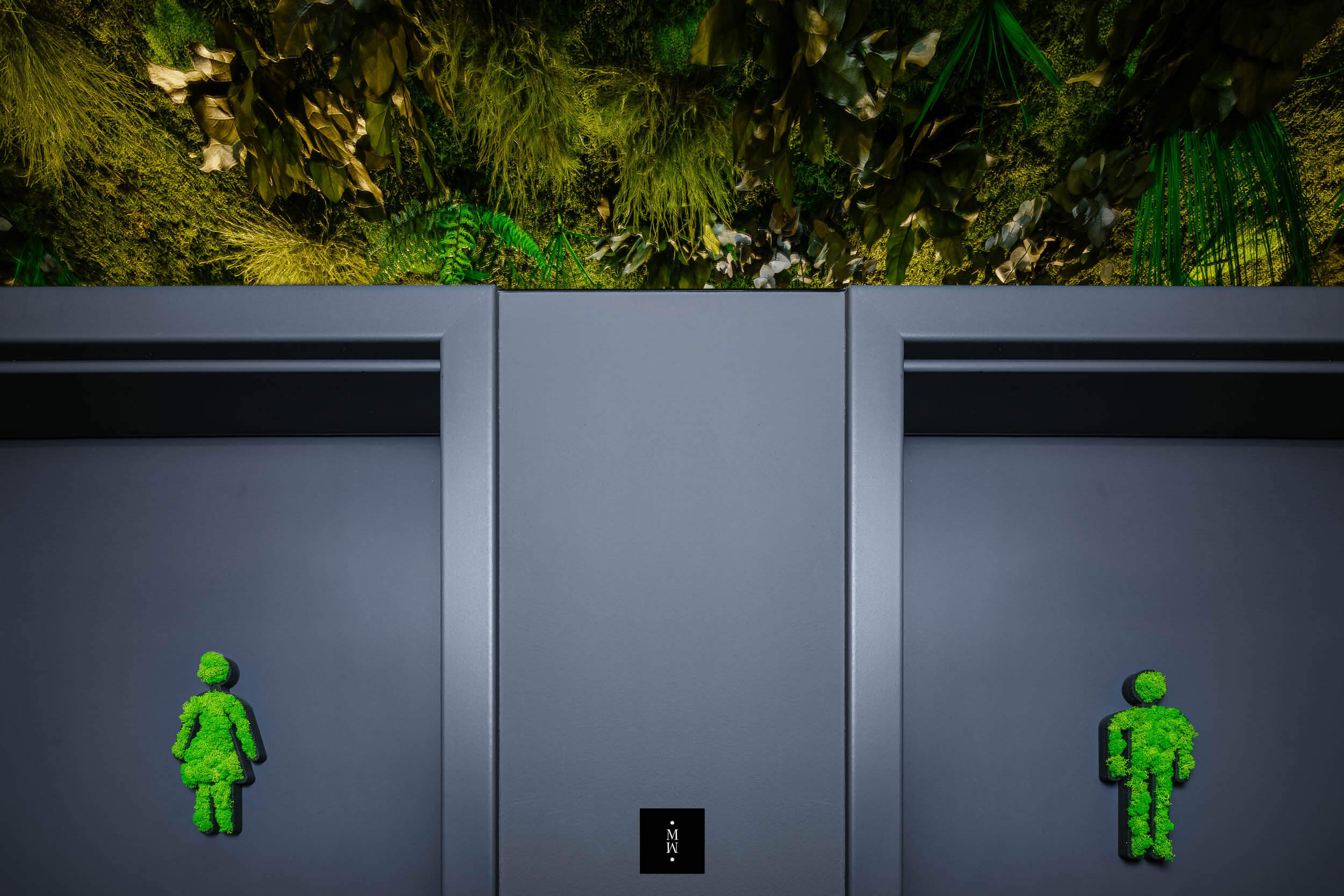 Dschungelmoosdecke und Moosfiguren auf Toilettentüren  in Nahaufnahme 