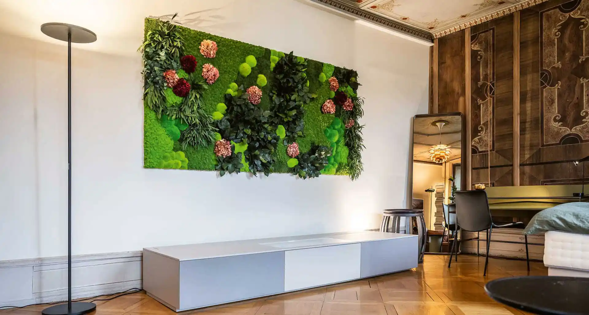 Großes Moosbild mit integrierten Blumen in einem modernen Wohnzimmer, bringt natürliche Frische und lebendige Akzente in den Raum.