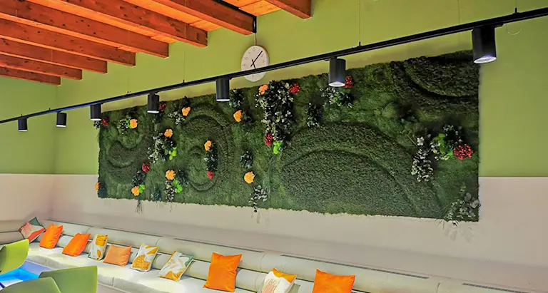 Große Mooswand mit Blumen in einem modernen Aufenthaltsraum mit Sitzbereich